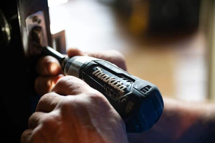 A repairman working on a door.