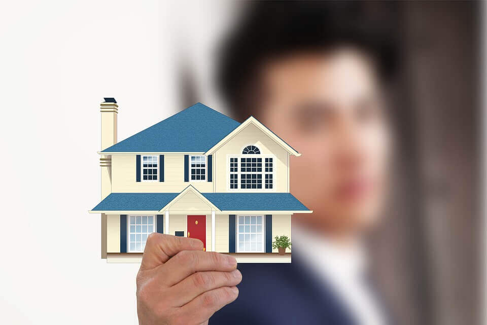 a man holding a picture of a house