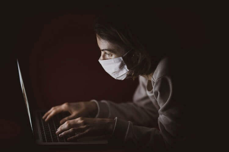 A woman wearing a mask browsing the internet