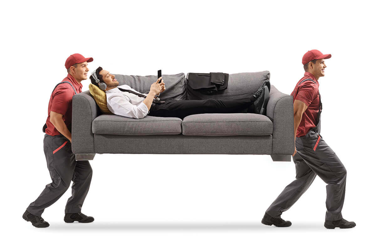 Movers carrying a person on a couch. 