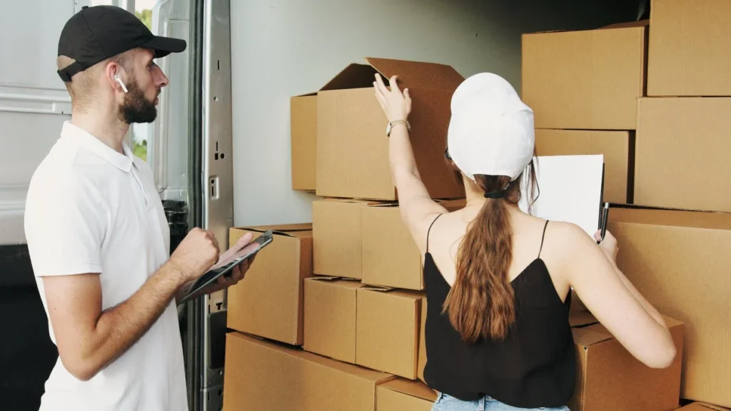 man and woman checking boxes in the moving truck