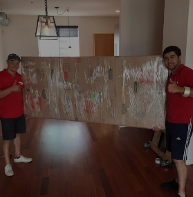 Movers holding a packed household item