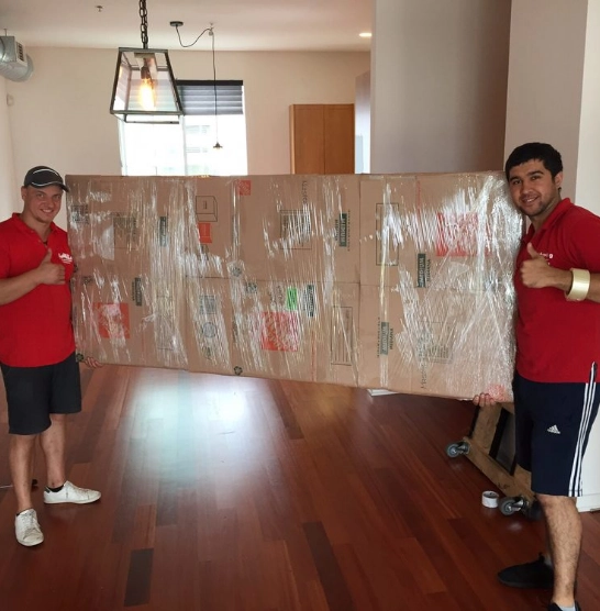 Movers posing with a wrapped item